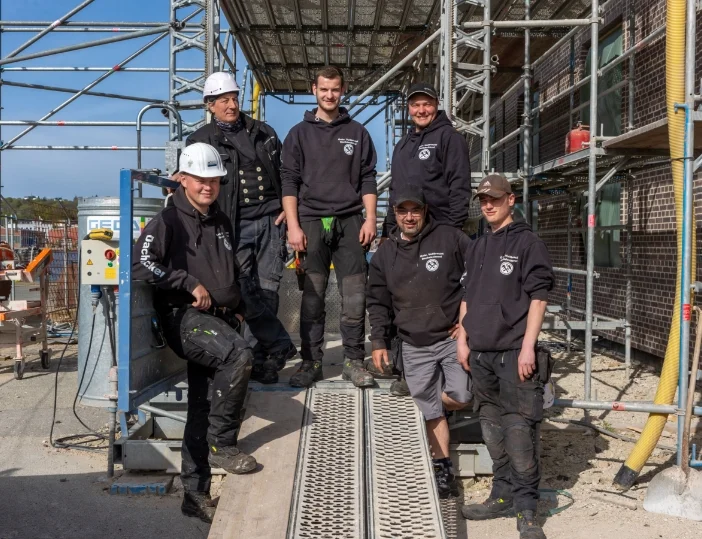 Dachdecker stehen vorm Baustellengerüst